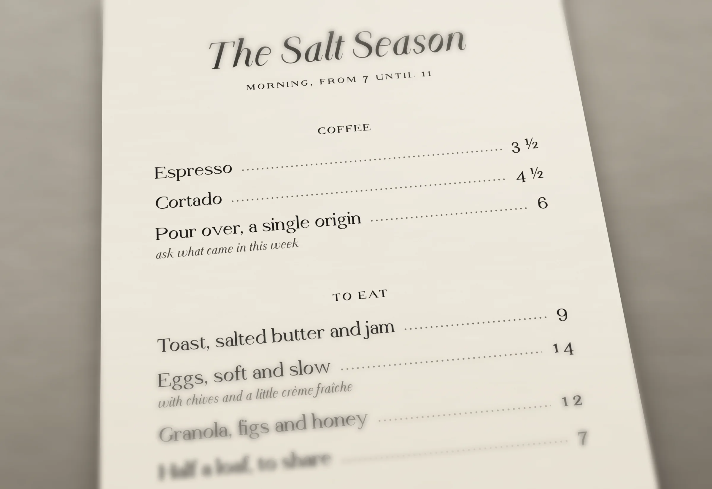 A café menu on stone: the dishes in Text Regular, the prices in oldstyle figures with fractions, the notes in italic.